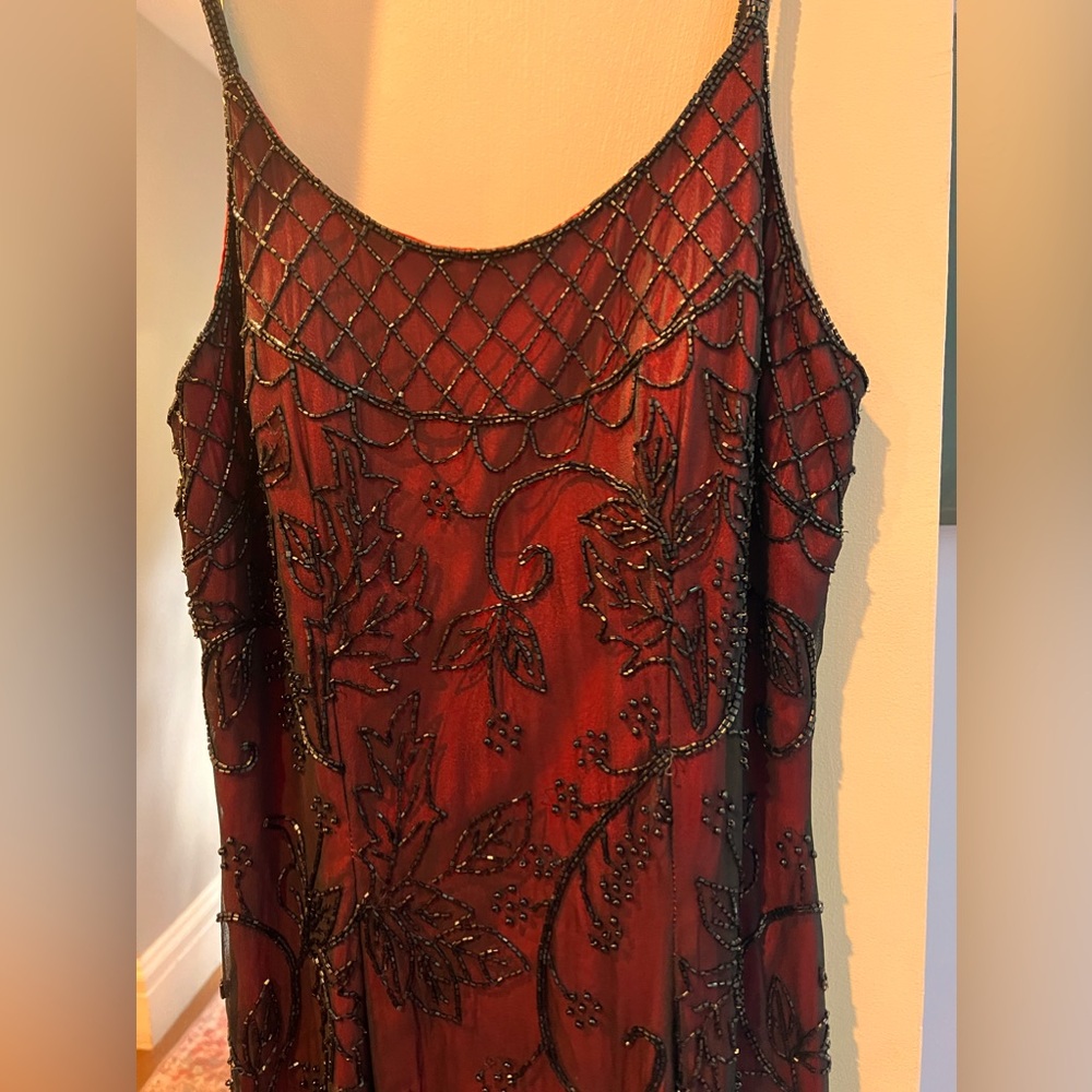 Long maxi beaded formal dress. Black beaded overlay over red background